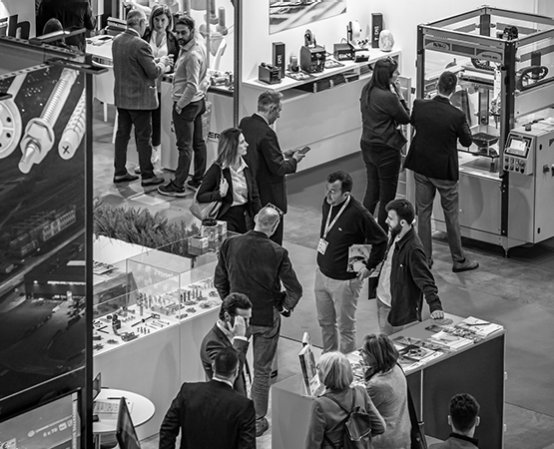 Exhibitors and visitors meet on a stand at Fastener Fair Italy
