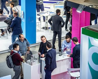 Exhibitors and visitors meet on a stand at Fastener Fair Italy