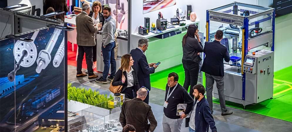 Exhibitors and visitors meet on a stand at Fastener Fair Italy