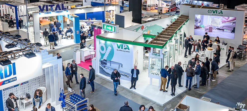 Sala espositiva con stand e i visitatori a Fastener Fair Italy